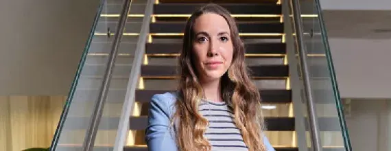 A female Director standing in-front of stairs at the Novartis office in Basel