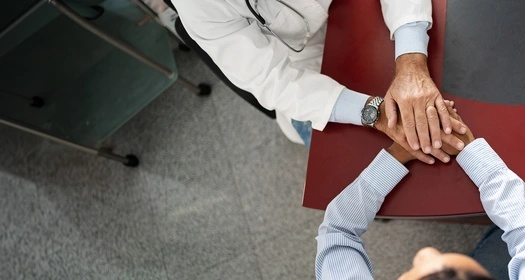Un medico tiene le mani a un paziente 