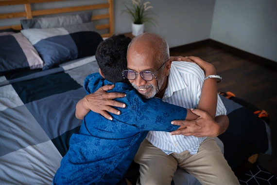 A grandfather and grandson hugging