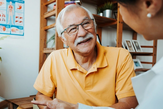 A healthcare professional and senior patient in a conversation using a tablet