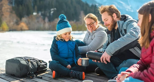 Eine Familie macht Pause neben einem Fluss