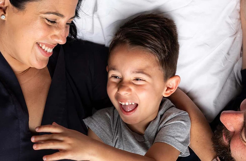 Parents snuggling with their son