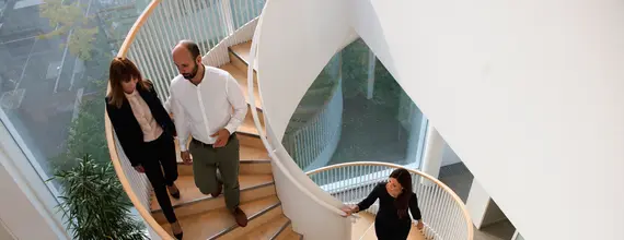 Professionals walking on a spiral staircase in an office building