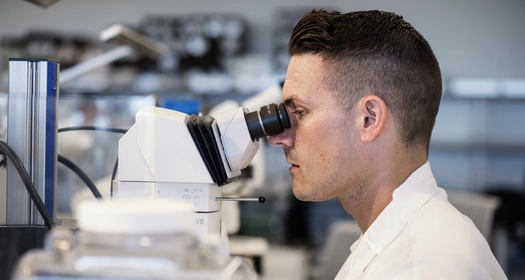 Scientist examining samples with a microscope in a laboratory